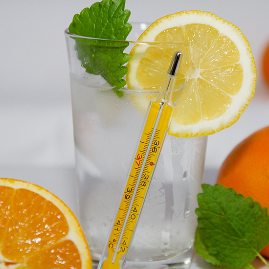 a glass of water with lemon, mint and orange to combat flu season