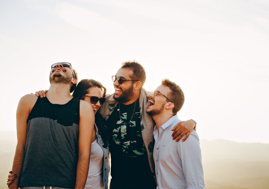 a group of friends laugh together in the mountains