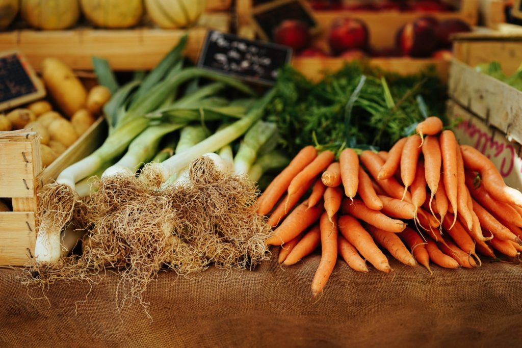 a stack of onions and carrots at the lynchburg community market